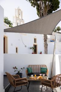a patio with a table and chairs and a solarium at Saint George Cave House in Fira