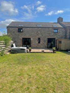 a brick house with a lawn in front of it at The Cottage in Carlisle