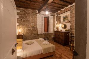 a bedroom with a bed and a brick wall at Boutique Ponte Vecchio in Florence