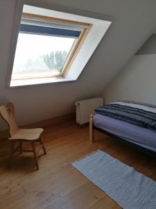 1 dormitorio con cama, ventana y silla en Spehnerhof en Vogt