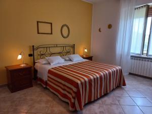 1 dormitorio con 1 cama con manta de rayas roja y blanca en Cascina Longoria, en Neive