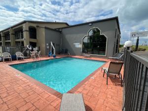 ein großer Pool mit Stühlen und ein Gebäude in der Unterkunft Homestay Horn Lake Southaven in Horn Lake