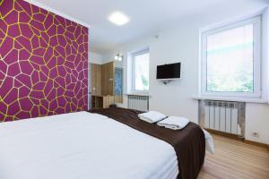 a bedroom with a large bed with a purple wall at Guest house "Golden Gate" in Kyiv