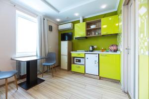 a kitchen with green cabinets and a table and chairs at Guest house "Golden Gate" in Kyiv