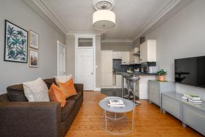 ein Wohnzimmer mit einem Sofa und einem Tisch in der Unterkunft The Holyrood Park Apartment in Edinburgh