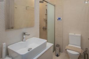 a bathroom with a white sink and a toilet at Vert House near The Beach in Agia Pelagia