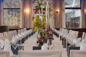 a long table with wine glasses and flowers on it at Sporthotel am Semmering in Semmering