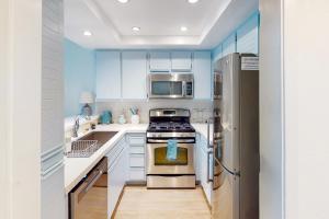 a kitchen with white cabinets and a stainless steel refrigerator at Remote Worker Paradise in Los Angeles