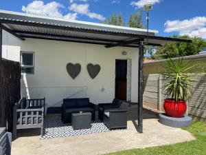 uma pérgola com cadeiras e um pátio em ikibiki em Beaufort West