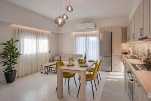 a kitchen and dining room with a table and chairs at Vert House near The Beach in Agia Pelagia +19 photos