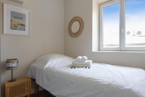 een slaapkamer met een wit bed en een raam bij Very nice flat with AC two steps away from the sea - Bandol - Welkeys in Bandol