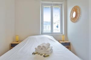 een kamer met een bed, handdoeken en een raam bij Very nice flat with AC two steps away from the sea - Bandol - Welkeys in Bandol