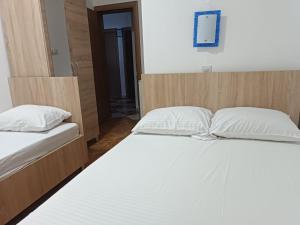 a bedroom with two beds with white pillows at Accommodation Milla in Ulcinj