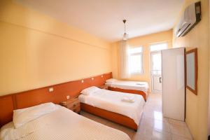 a hotel room with two beds and a window at Fethiye Apart Otel in Fethiye
