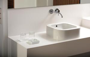 a white bathroom with a sink and glasses on a counter at Hotel INNdependence in Mainz