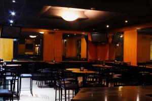 a dining room with tables and chairs and televisions at El Regio in Monterrey