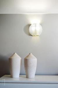 two white vases sitting on a table with a light at Lisbon Surf + Beach Villa in Costa da Caparica