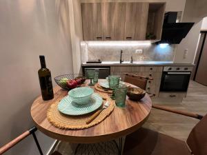 a kitchen with a wooden table with a bottle of wine at Supreme Malibu Suit in Alexandroupoli