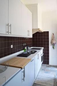 a kitchen with white cabinets and a sink at Lisbon Surf + Beach Villa in Costa da Caparica