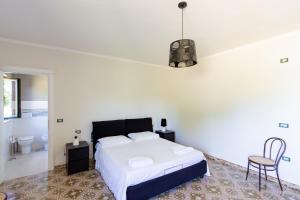 a white bedroom with a bed and a bathroom at Casa Fiorella - Irpinia in Lioni