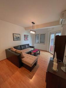 uma sala de estar com um sofá e uma mesa em Korun's Lakeview Apartment em Lagadin
