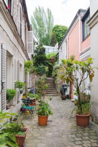 Une allée avec des plantes en pot et des escaliers dans l'établissement Le Grand Maulnes, à Paris