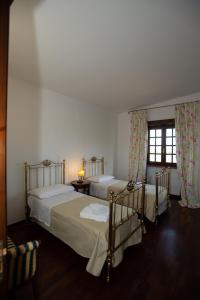 2 Einzelbetten in einem Zimmer mit Fenster in der Unterkunft Villa del Ruach in Struda