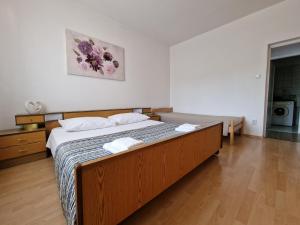- une chambre avec un grand lit en bois dans l'établissement Apartment Šoštarić, à Krk