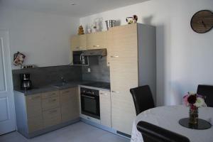 a kitchen with a stove and a table with a dining room at Logement agréable et tranquille in Fontenay-Trésigny
