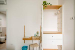um quarto com um armário com uma mesa e uma secretária em Guesthouse Tree Rooms Modern em Bérgamo