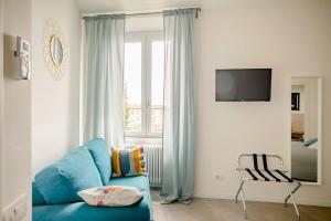 Guesthouse Tree Rooms Modern في بيرغامو: غرفة معيشة مع أريكة زرقاء ونافذة
