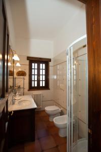 ein Badezimmer mit zwei WCs, zwei Waschbecken und einer Dusche in der Unterkunft Villa del Ruach in Struda