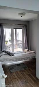 uma cama grande num quarto com uma janela grande em Hotelik Kościerzyna em Kościerzyna