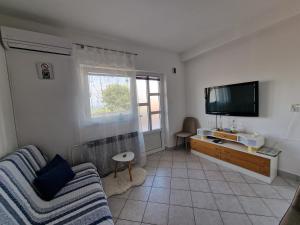 a living room with a couch and a flat screen tv at Apartment Šoštarić in Krk