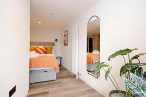 a bedroom with two beds and a mirror at Charming Studios near Holyrood Park & Calton Hill in Edinburgh