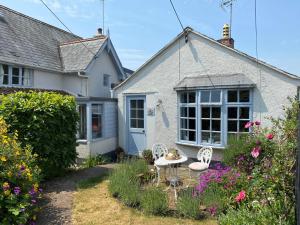 a cottage with a table and chairs in the garden at Orchard Cottage in Sidmouth