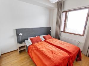a bedroom with a large bed with an orange blanket at Holiday Home Nordic chalet 9312 by Interhome in Ylläsjärvi