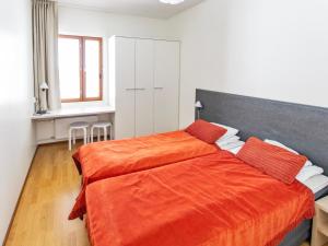 a bedroom with a bed with an orange blanket at Holiday Home Nordic chalet 9312 by Interhome in Ylläsjärvi