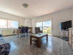 een woonkamer met een tafel en een televisie bij Holiday Home Montserrat by Interhome in Segur de Calafell