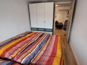 - un lit avec une couverture colorée dans l'établissement Apartment Garden-1 by Interhome, à Karl