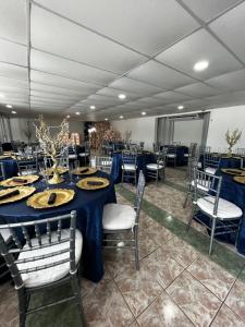 a banquet hall with blue tables and chairs at Douglas Highway Inn Hotel in Cabo Rojo