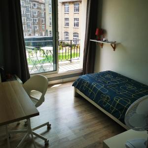 sypialnia z łóżkiem i dużym oknem w obiekcie Résidence Zola w Hawrze