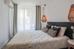- une chambre avec un grand lit blanc et des oreillers dans l'établissement Appartement Ebène - Welkey, à Antibes