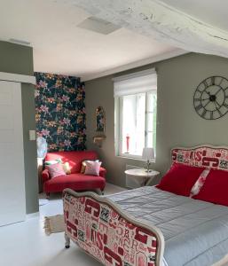 Le Verdier的住宿－Le pigeonnier，一间卧室配有一张床和一张红色的沙发
