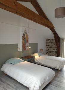 two beds in a room with a brick wall at Gîte de la Tournelle in Pradelles