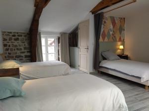 a bedroom with two beds and a brick wall at Gîte de la Tournelle in Pradelles