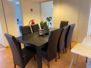 uma mesa de jantar preta com cadeiras pretas em Single room with shared spaces em Vennesla