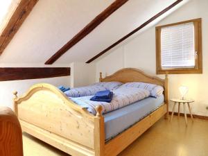 1 dormitorio con 1 cama con marco de madera en Chalet Tschingeli by Interhome, en Niedergampel