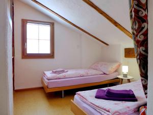Duas camas num pequeno quarto com uma janela em Chalet Tschingeli by Interhome em Niedergampel
