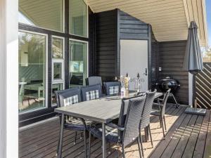 una terrazza in legno con tavolo e sedie. di Holiday Home Greta - 200m from the sea in Bornholm by Interhome a Vester Sømarken